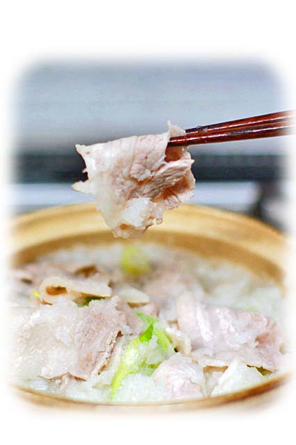 土鍋の中のぶたバラ肉を箸でつまみ上げた写真